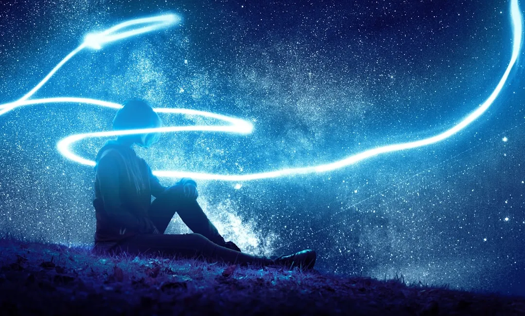 Paysage étoilé avec personne assise sous un ciel nocturne avec traînées lumineuses et voie lactée, image inspirante pour philosophie et réflexion, symbolise la quête de connaissance et la créativité intellectuelle.