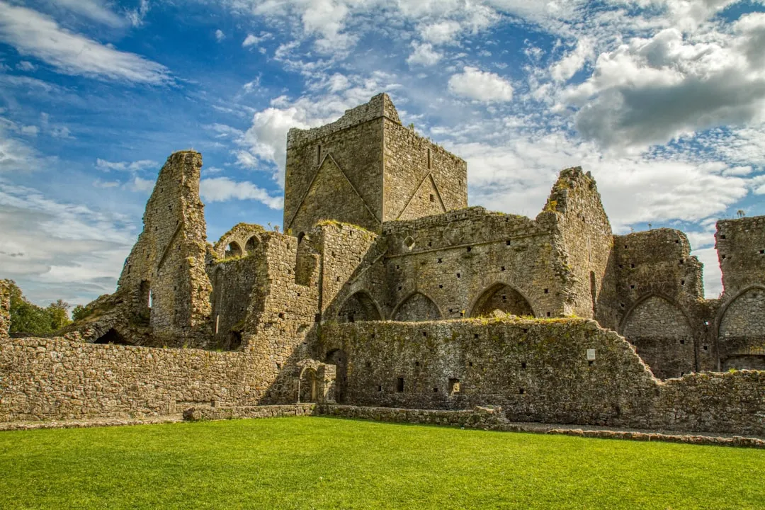 Ancienne ruines d’un château médiéval en pierre sur fond de ciel bleu nuageux, témoignage historique et culturel, idéal pour philosopher sur le temps et la durabilité.